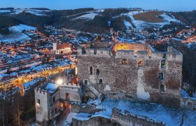 Burgruine Kirchschlag bei Nacht mit Ort im Hintergrund, © Wiener Alpen, Foto: Walter Strobl